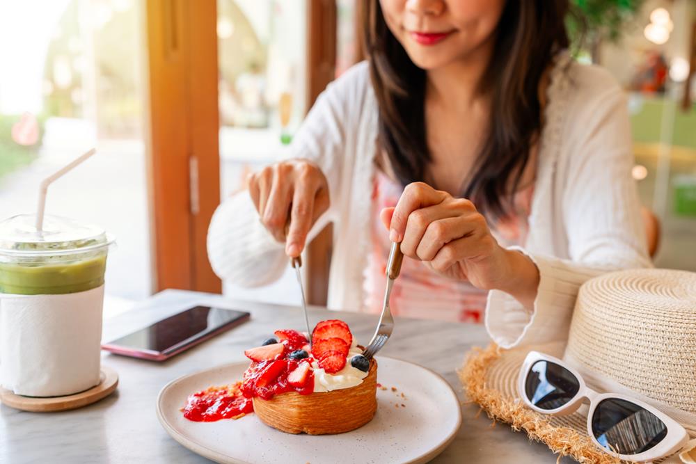 A woman eating a dessert at a cafe
