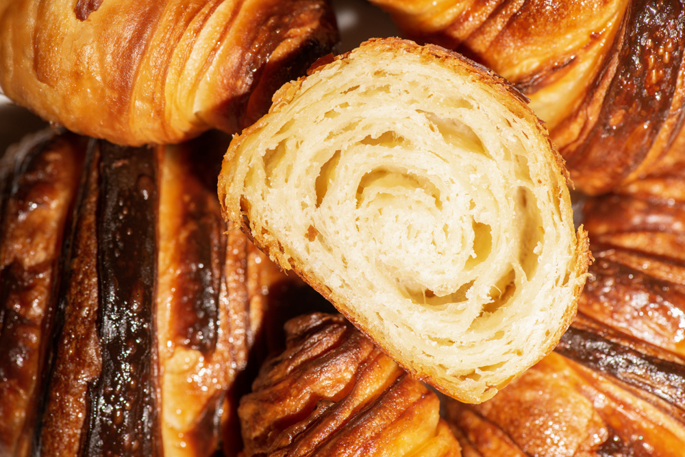 Detailed and closeup photo of a fresh baked plain buttery and flaky croissant