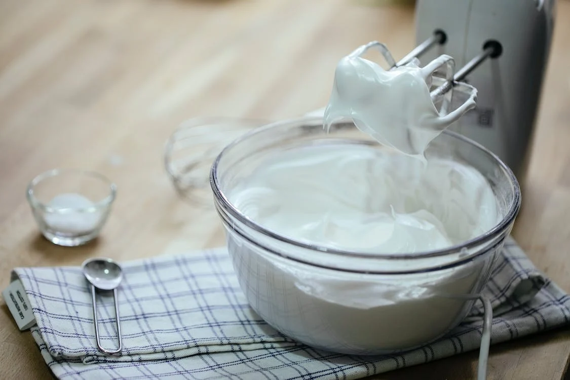 Composition on bowl with delicious sour cream near the mixer