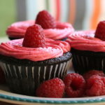 The vibrant color of strawberry in buttercream icing of a chocolate cake.