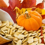 spilling pumpkin seeds with white husks in a ceramic yellow bowl, small size pumpkin